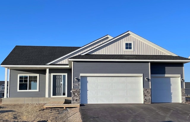 9792 32nd St NE, Saint Michael, MN 55376 - view of front facade with driveway, a shingled roof, a garage, and board and batten siding