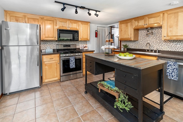 332 Riverside Ave S, Sartell, MN 56377 - kitchen featuring appliances with stainless steel finishes, a sink, dark countertops, tasteful backsplash, and rail lighting