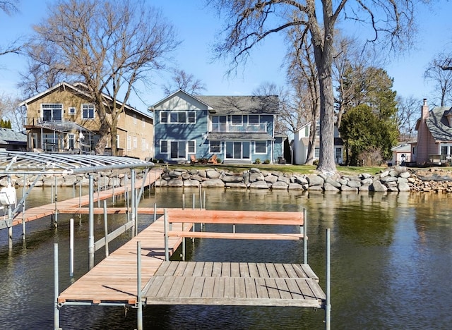 dock area with a water view and a balcony