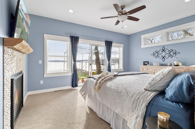 bedroom with a glass covered fireplace, recessed lighting, access to exterior, carpet flooring, and baseboards