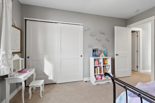 bedroom featuring light carpet, a closet, and baseboards