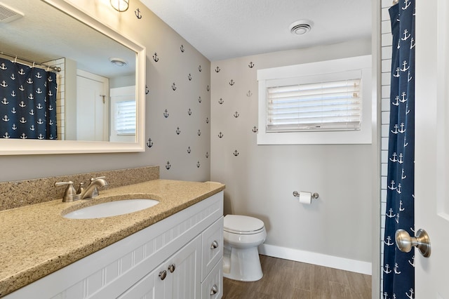 bathroom with visible vents, baseboards, toilet, and wood finished floors