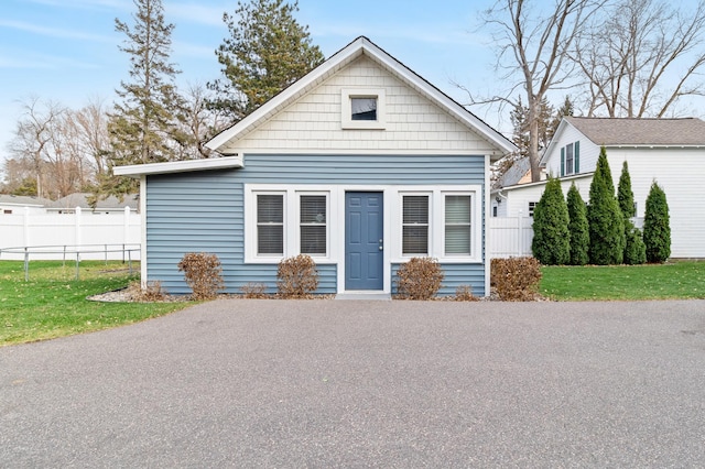 view of front of home with a front lawn and fence