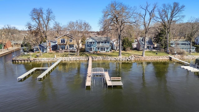 view of dock with a lawn, a residential view, and a water view