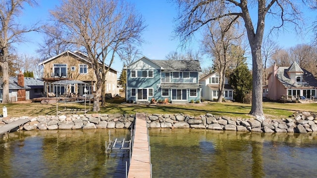 dock area with a yard, a water view, and a balcony