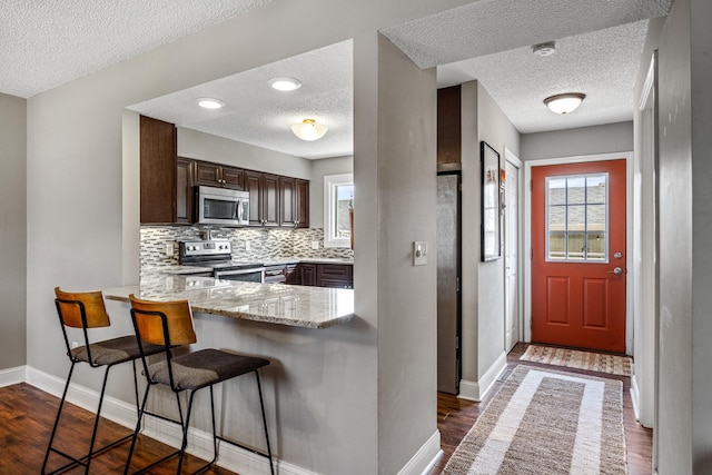 kitchen with plenty of natural light, a textured ceiling, and stainless steel appliances