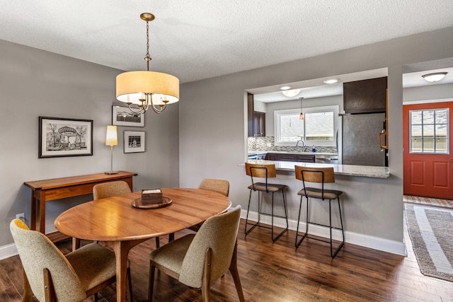 dining room with baseboards, a chandelier, and dark wood-type flooring