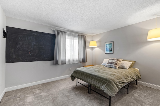 bedroom featuring baseboards, carpet flooring, and a textured ceiling