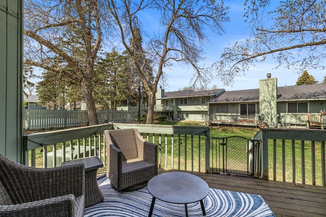 deck featuring fence, a yard, and a residential view