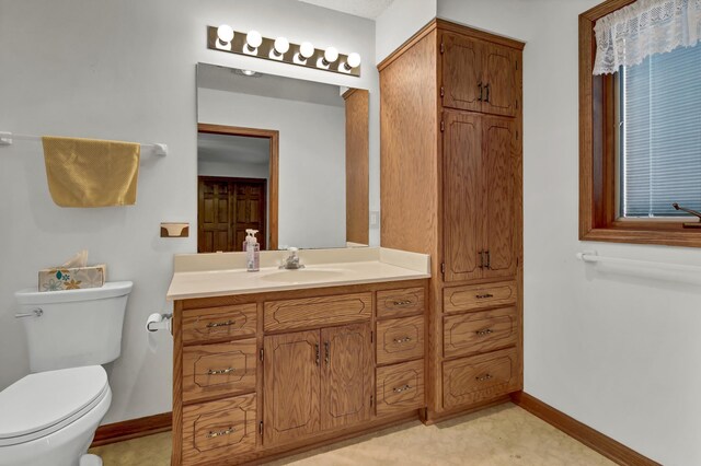 5470 Saint Mary Dr NW, Rochester, MN 55901 - bathroom with toilet, vanity, and baseboards