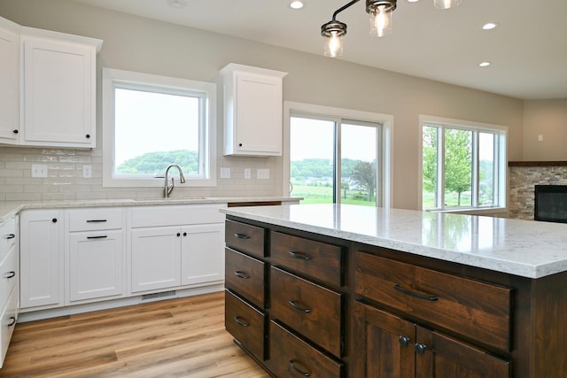 633 Manheim Ave, Saint Charles, MN 55972 - kitchen with a sink, white cabinetry, decorative backsplash, dark brown cabinetry, and recessed lighting