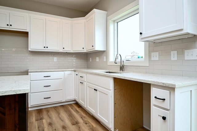 633 Manheim Ave, Saint Charles, MN 55972 - kitchen featuring a sink, light stone counters, backsplash, light wood-style floors, and white cabinets