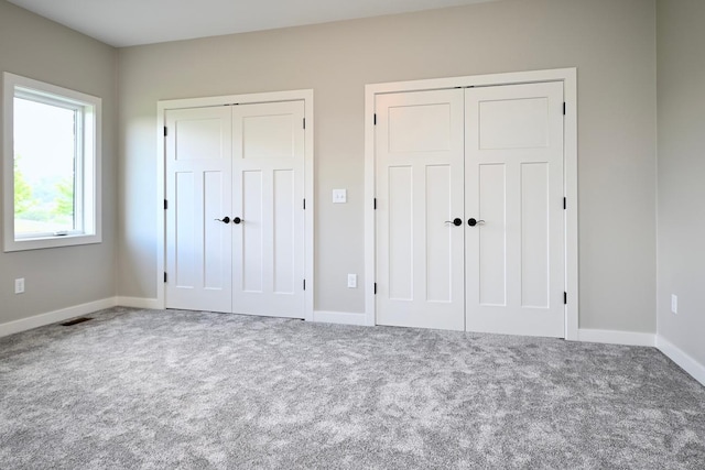 633 Manheim Ave, Saint Charles, MN 55972 - unfurnished bedroom featuring two closets, carpet floors, and baseboards
