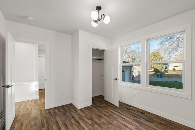 2308 Shadywood Rd, Orono, MN 55391 - unfurnished bedroom with baseboards, dark wood finished floors, a closet, and a chandelier