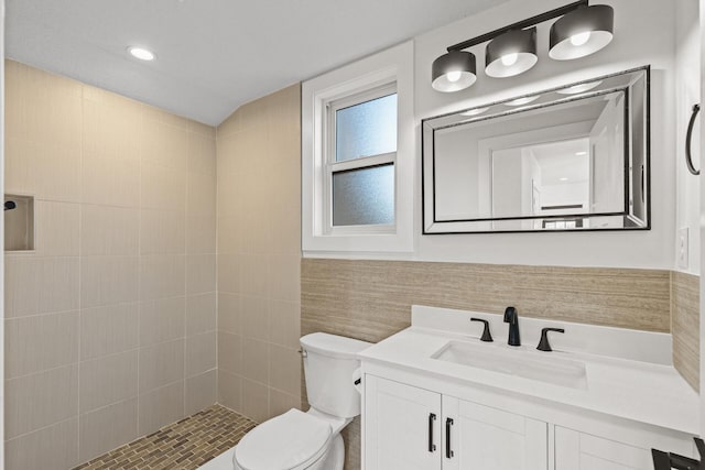 2308 Shadywood Rd, Orono, MN 55391 - bathroom featuring toilet, vanity, tiled shower, and tile walls
