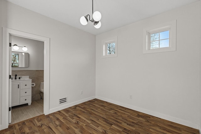 2308 Shadywood Rd, Orono, MN 55391 - unfurnished bedroom with multiple windows, a chandelier, dark wood finished floors, baseboards, and tile walls