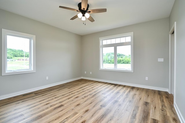 spare room with a ceiling fan, wood finished floors, and baseboards
