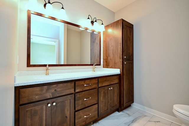 full bathroom featuring marble finish floor, toilet, baseboards, and a sink