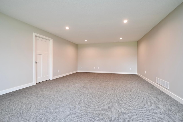 empty room with recessed lighting, visible vents, dark colored carpet, and baseboards