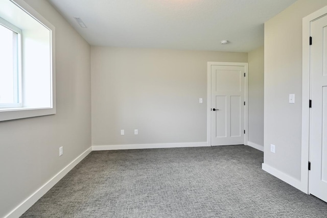 unfurnished room with baseboards and carpet floors