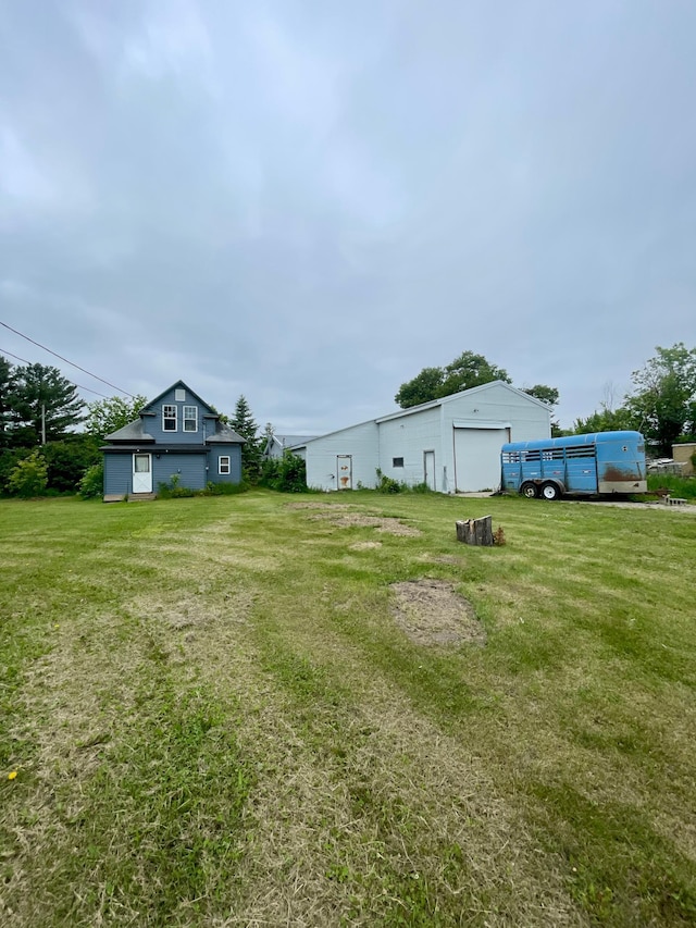320 8th St SE, Staples, MN 56479 - view of green lawn with a detached garage and an outdoor structure
