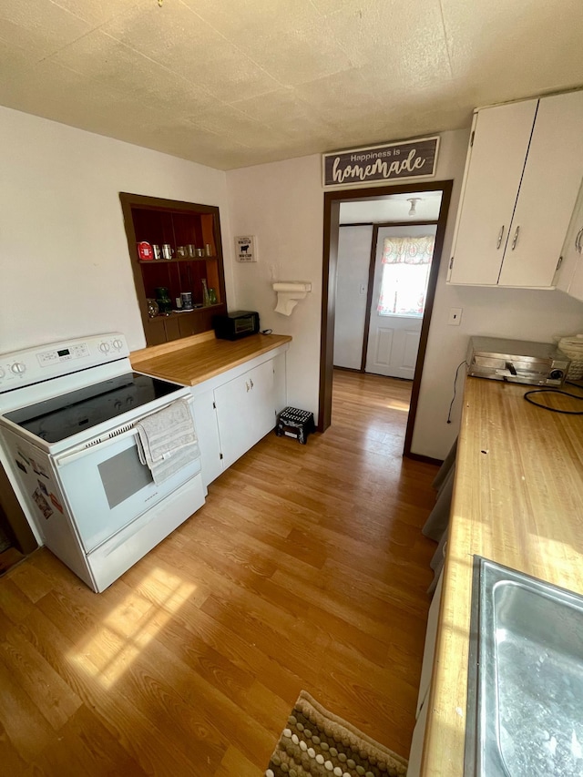 320 8th St SE, Staples, MN 56479 - kitchen featuring white range with electric cooktop, white cabinets, light wood-style floors, and light countertops