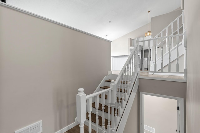 stairway featuring baseboards, visible vents, and wood finished floors