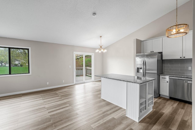 kitchen with open shelves, light wood-type flooring, backsplash, appliances with stainless steel finishes, and a chandelier