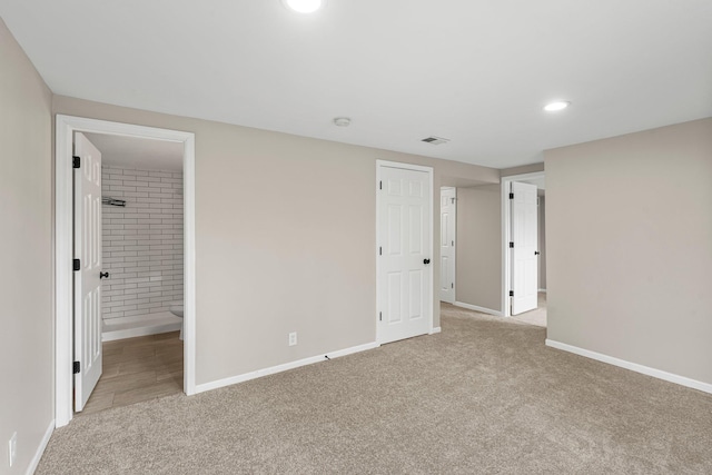 unfurnished bedroom featuring ensuite bath, visible vents, recessed lighting, light carpet, and baseboards