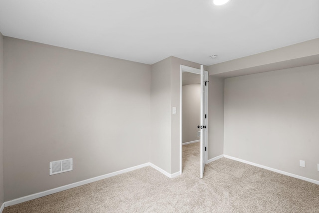 spare room with light colored carpet, baseboards, and visible vents