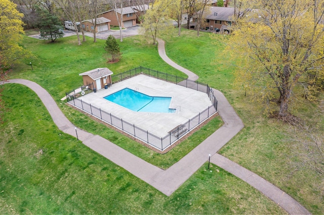 community pool featuring a yard, an outdoor structure, and fence
