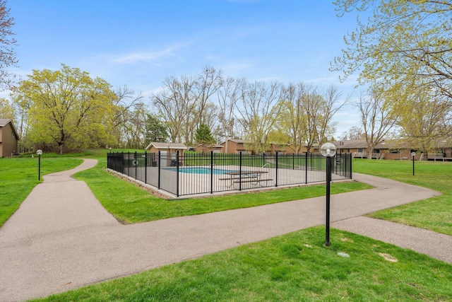 community pool with a yard and fence