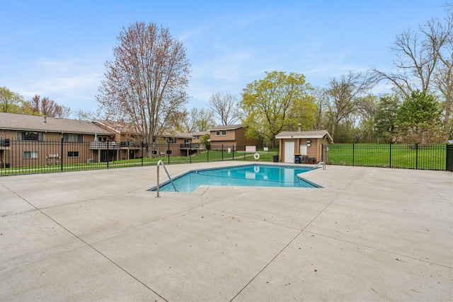pool with an outbuilding, a patio, a residential view, and fence