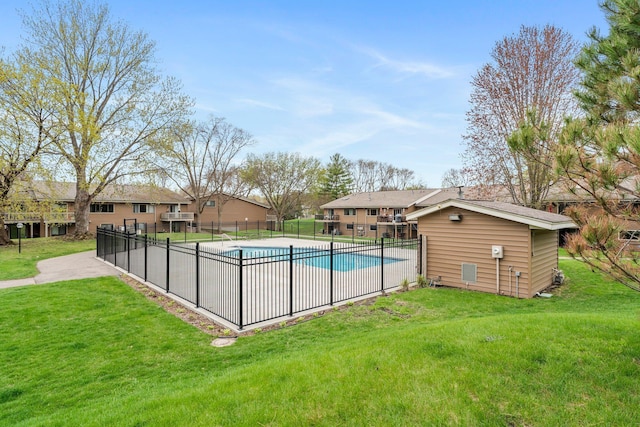 community pool featuring fence and a lawn
