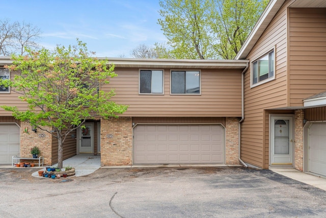 view of front of property with driveway, brick siding, and an attached garage