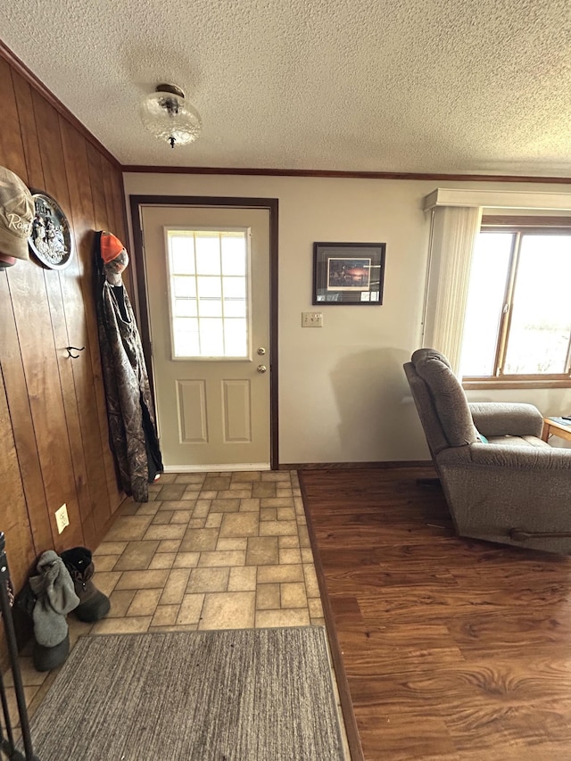 43475 310th Ave NE, Gatzke, MN 56724 - doorway featuring wood walls, a textured ceiling, light wood-style floors, and ornamental molding