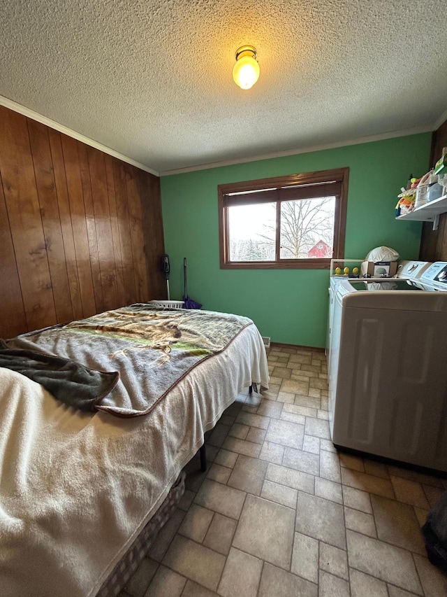 43475 310th Ave NE, Gatzke, MN 56724 - bedroom featuring wooden walls, stone finish flooring, a textured ceiling, washer and dryer, and crown molding
