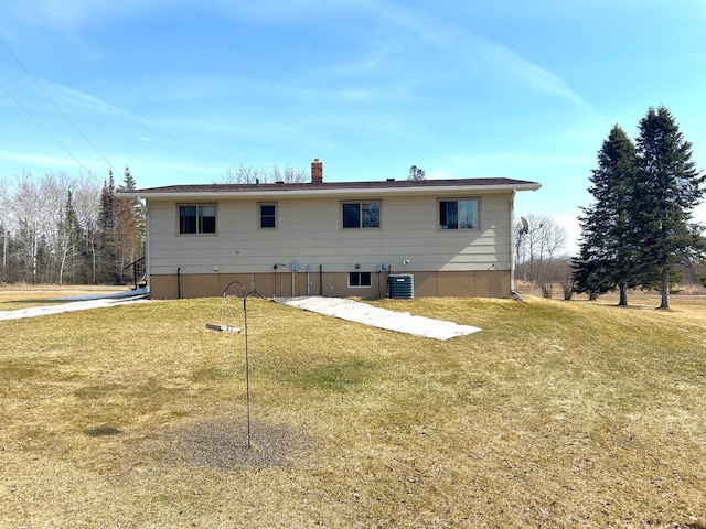 43475 310th Ave NE, Gatzke, MN 56724 - back of house with central AC unit, a lawn, and a chimney