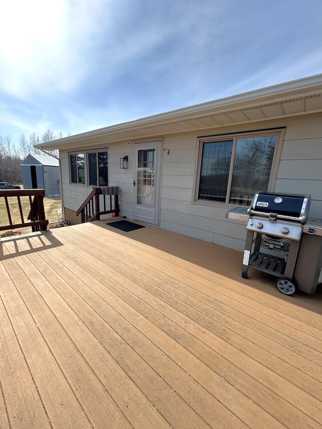 43475 310th Ave NE, Gatzke, MN 56724 - wooden deck featuring an outbuilding, a storage unit, and a grill