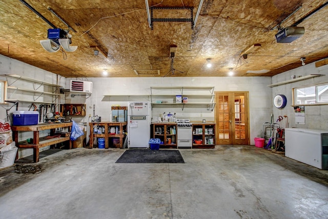 garage featuring a workshop area, a garage door opener, freestanding refrigerator, and refrigerator