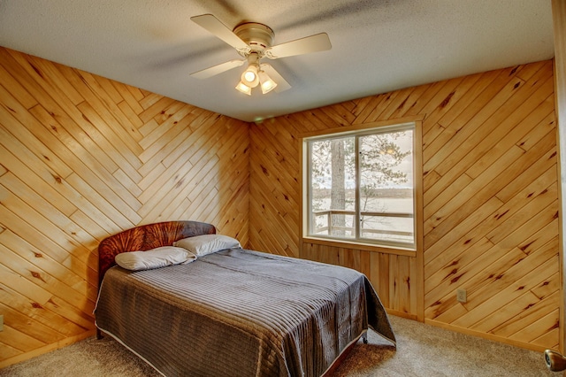 bedroom with carpet floors, wooden walls, ceiling fan, and baseboards