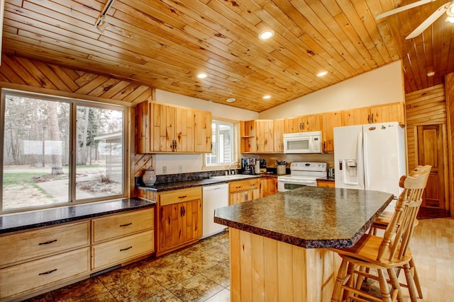 kitchen featuring ceiling fan, a sink, white appliances, a breakfast bar area, and vaulted ceiling