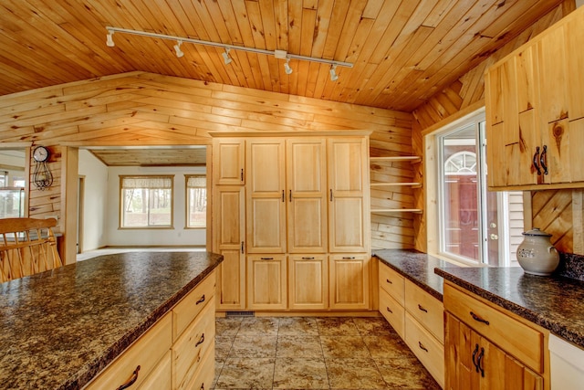 kitchen with light brown cabinets, dark countertops, wooden ceiling, rail lighting, and vaulted ceiling
