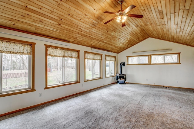 unfurnished room featuring ceiling fan, carpet, wooden ceiling, and a wood stove