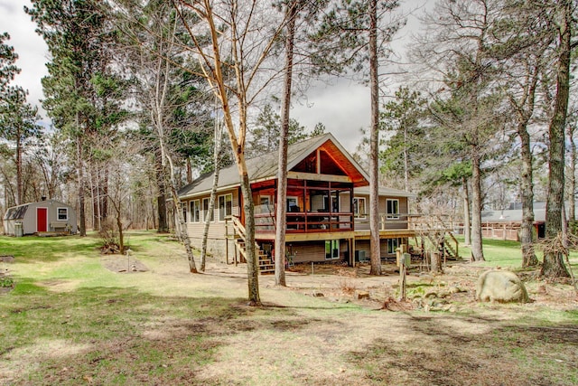 back of property featuring stairs, a lawn, and a wooden deck