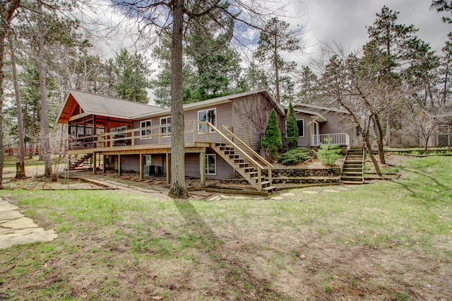 back of property with stairs, a sunroom, a yard, and a deck