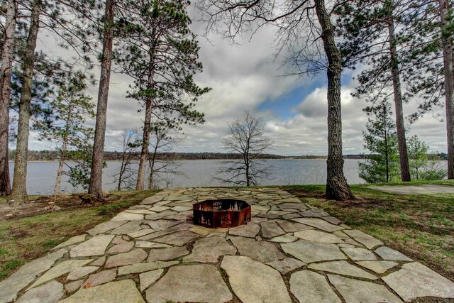 view of patio with a water view and an outdoor fire pit