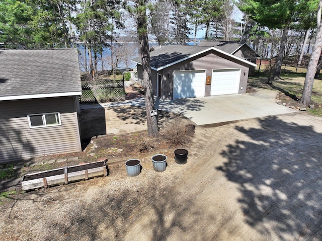 view of home's exterior featuring a garage and roof with shingles
