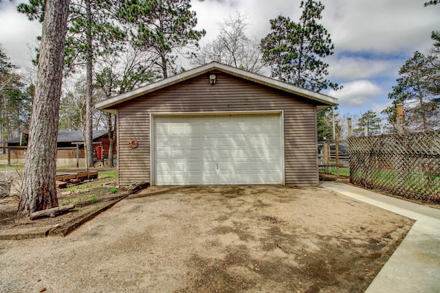 detached garage featuring fence