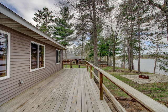 wooden deck featuring a water view and an outdoor fire pit